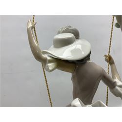 Lladro figure, Swinging, modelled as a woman sat on a swing attached to a tree branch, sculpted by Salvador Debon, no 1297, year issued 1974, year retired 1989, H41cm 