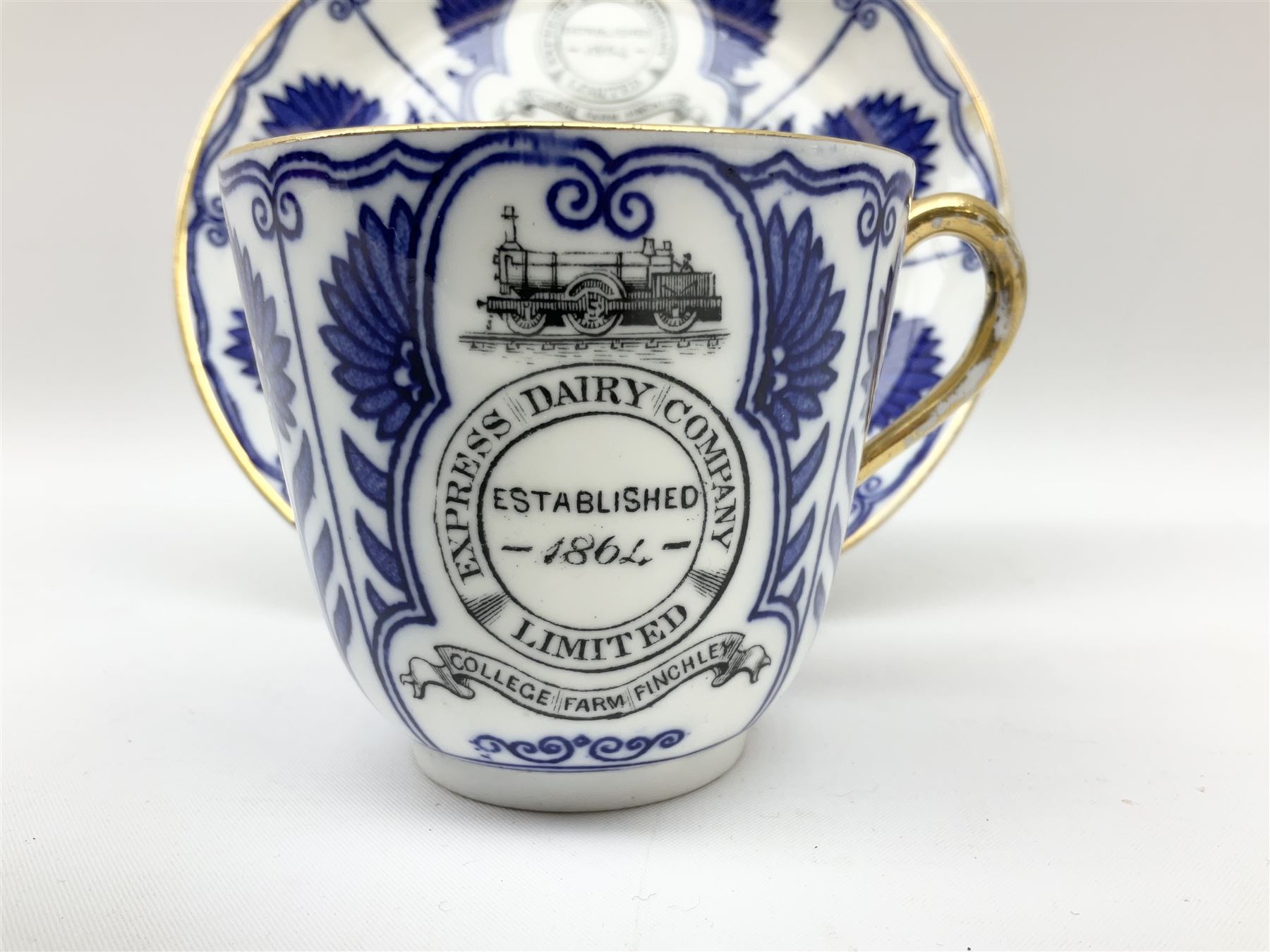 Late 19th century Coalport porcelain cup and saucer in the 'Aster' pattern bearing the crest of Express Dairy Company Limited, College Farm, Finchley and decorated with a steam locomotive