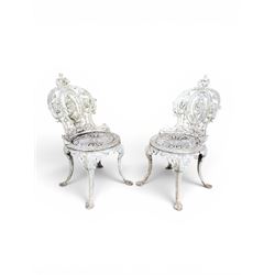 Pair of white painted cast metal garden chairs, ornate reclined backs, circular pierced se...