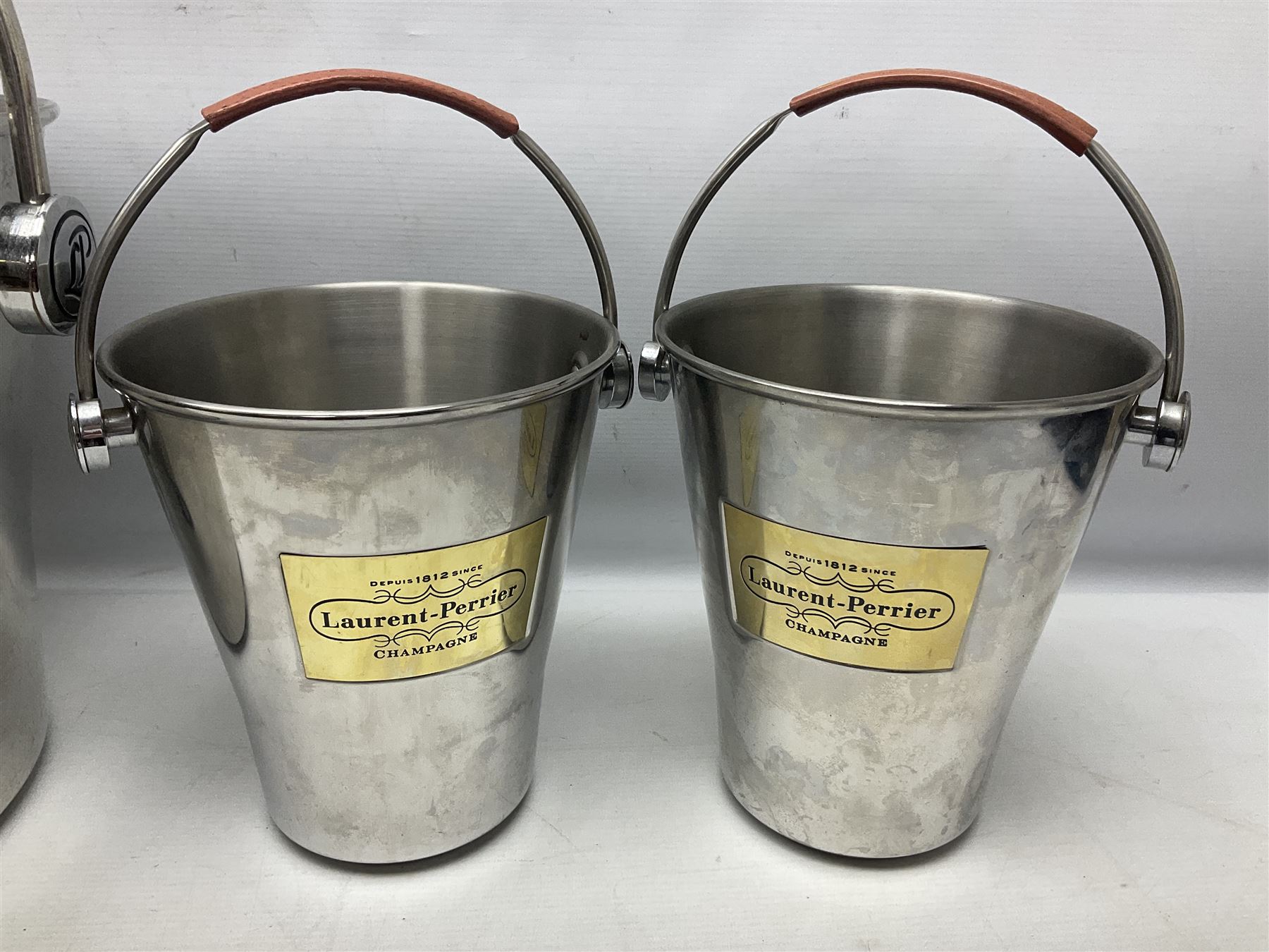 Stainless steel Laurent-Perrier champagne bucket, with engraved brass plaque and grip to swing handle, together with three matching smaller, largest D38cm (4)