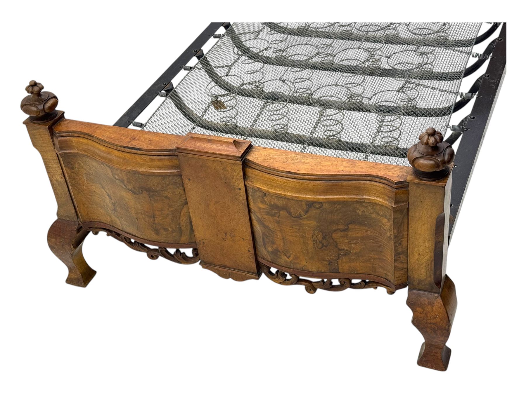 Mid-20th century walnut single bedstead, high shaped headboard, footboard with turned finials and scrollwork carvings, complete with 'Vono' iron frame, raised on cabriole supports
