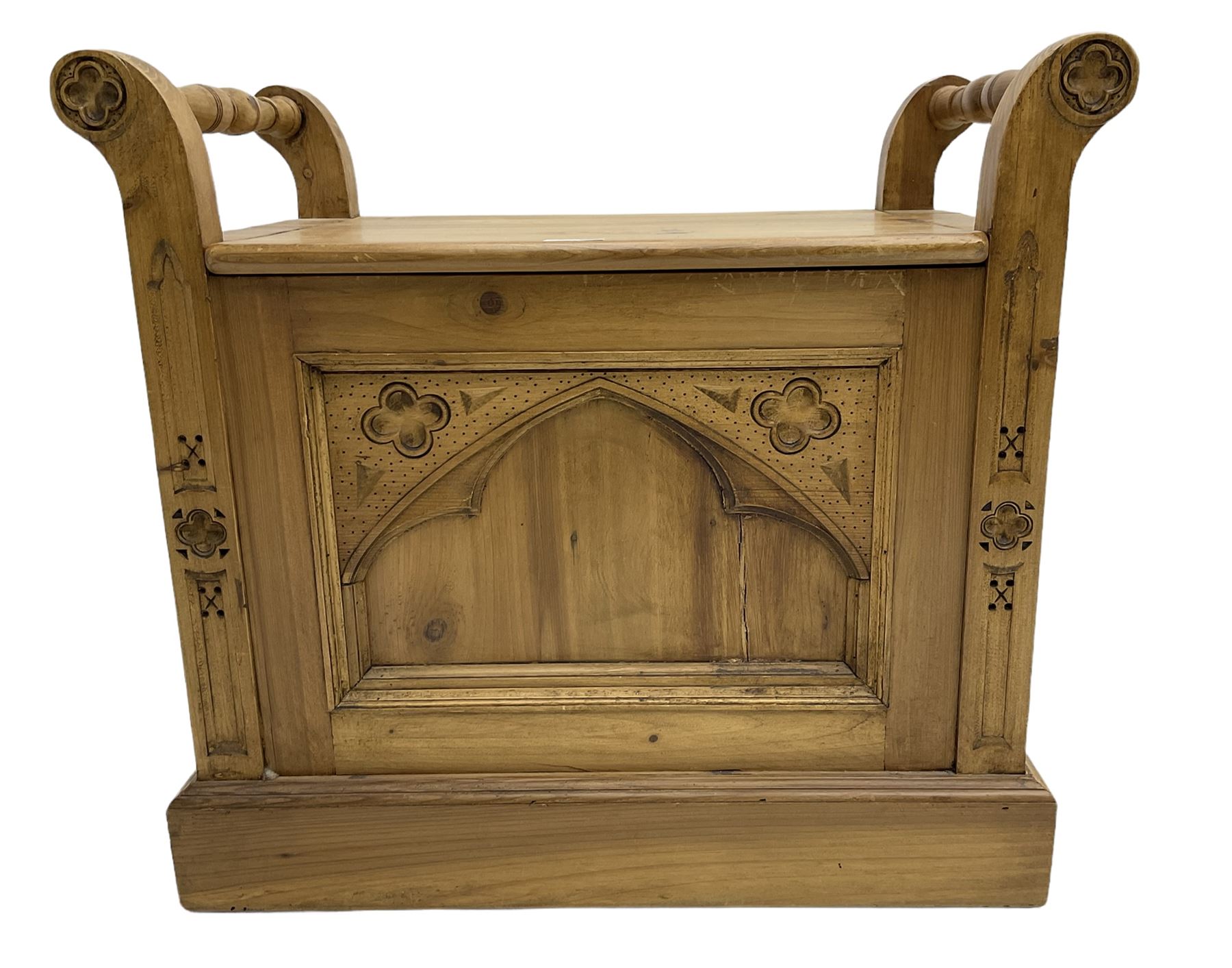 Gothic style pine stool with hinged box seat, decorated with flower head motifs, plinth base