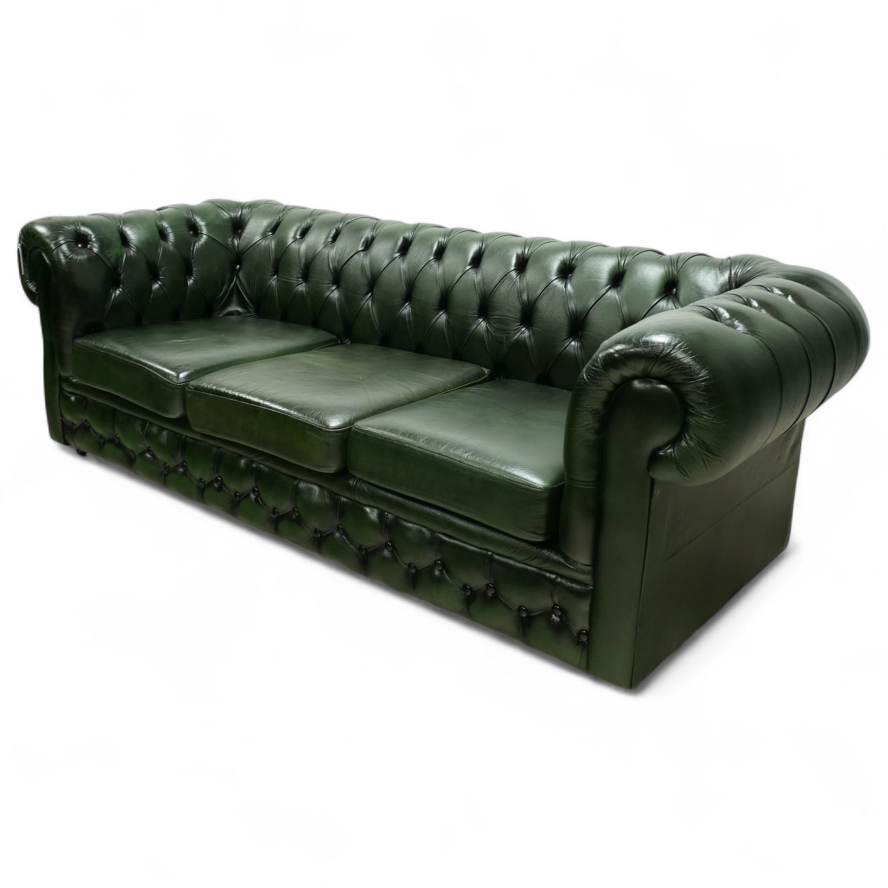 Late 20th century chesterfield style sofa upholstered in green leather, with deep buttoned back and arms above three loose cushions, continuous scroll arms and front, on concealed block feet