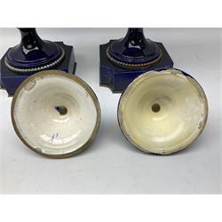 Pair of French large cobalt blue lidded urns, probably 19th century, the body decorated with ormolu ram's heads and ornate foliate design, the domed cover with brass berry finial, raised upon pedestal base with beaded decoration upon shaped plinth, H52cm