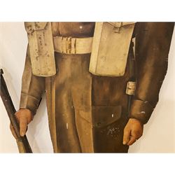 Military Outfitters hand painted life size wooden cut out figure of a WW1 soldier standing at ease holding a gun by his side, marked Stening Signs; hardboard on planked frame H199cm