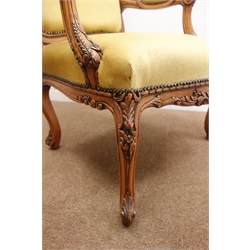  French style walnut framed elbow chair, shaped floral carved cresting rail, upholstered back, seat and arms, acanthus cabriole supports, W70cm  