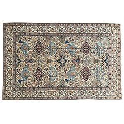 Persian Nain ivory ground rug, wool with silk inlay, the field decorated with stylised gul motifs with palmettes surrounded by interlacing foliate patterns, the guarder border decorated with repeating flower heads and scrolling vines