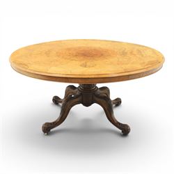 Victorian figured walnut oval loo tilt top table, raised on a heavily carved quatriform ba...
