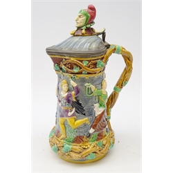  Victorian Minton Majolica 'Tower' flagon, with Jester finial, the body relief moulded with mediaeval dancing figures & hinged pewter lid, impressed marks to base, H33.5cm  