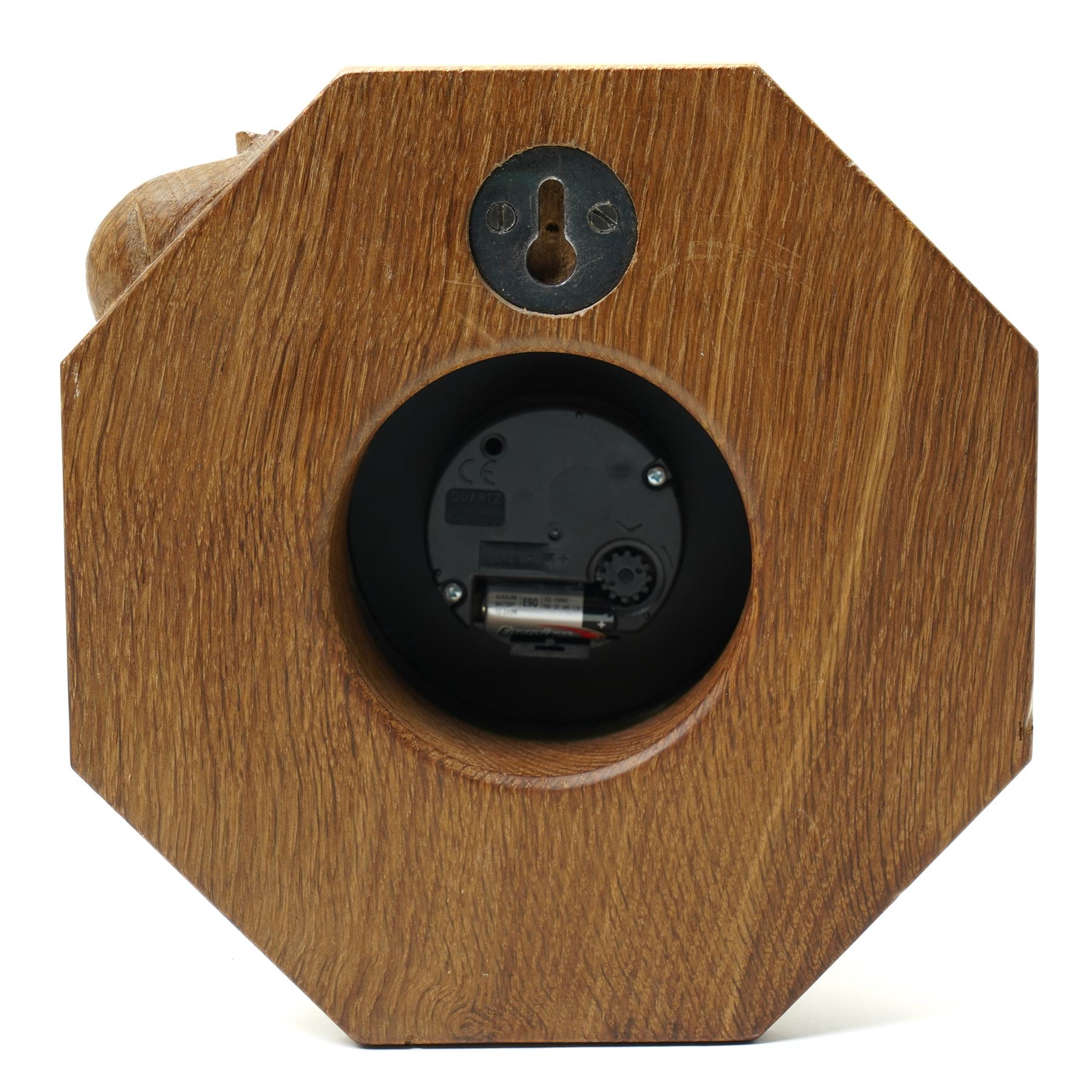 Mouseman - oak wall clock, circular Roman dial in brass drum on moulded octagonal mount, , fitted with battery operated Quartz movement, with carved mouse signature, by the workshop of Robert Thompson of Kilburn