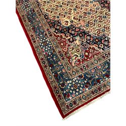 Persian Moud carpet, the field decorated all-over with Herati motifs, central medallion and spandrels decorated with stylised plant and flower head motifs, repeating border with guard