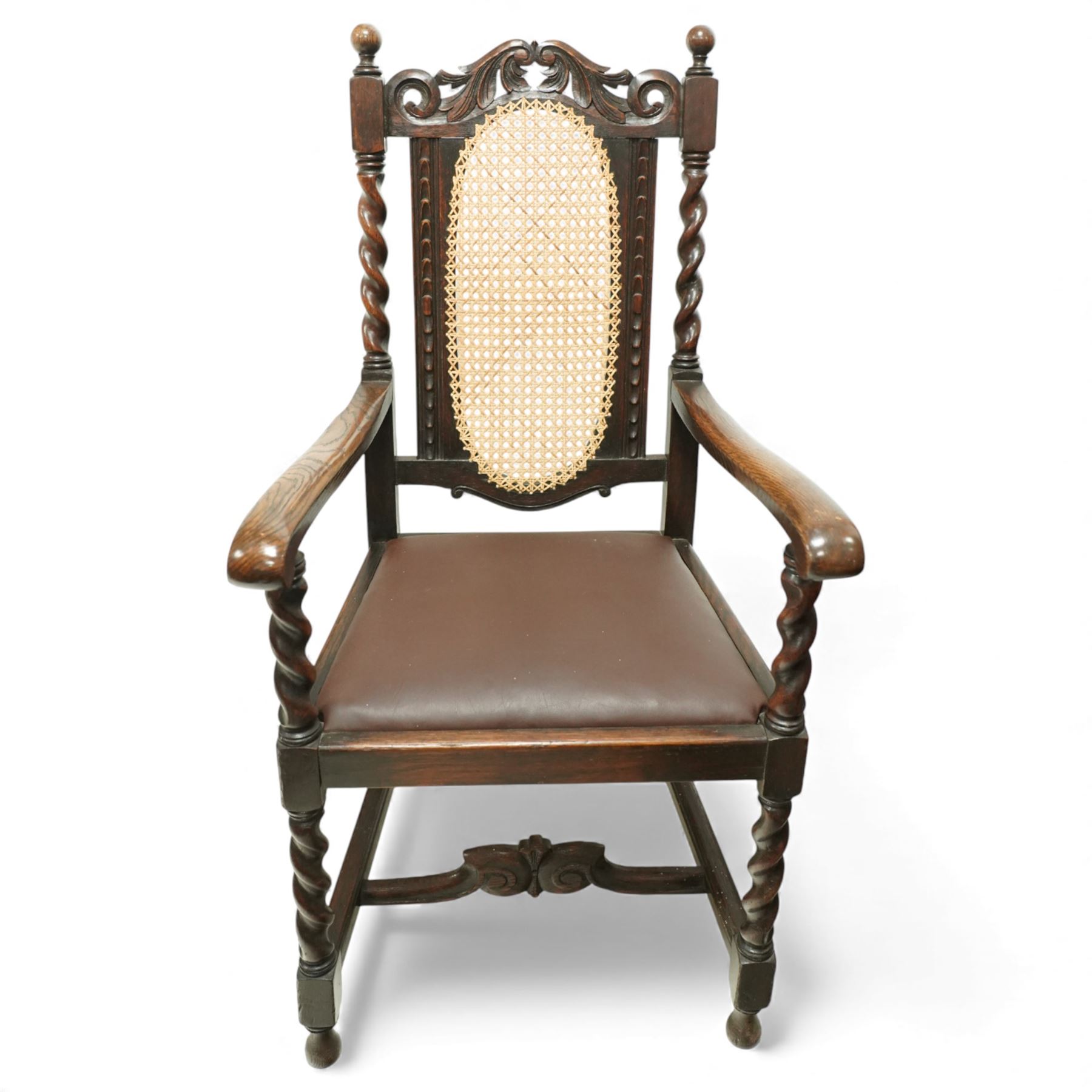 Victorian Jacobean revival oak carver chair, carved scroll cresting rail over an oval back panel later caned, open arms on barley-twist supports, padded seat, raised on spiral turned legs united by a shaped front stretcher
