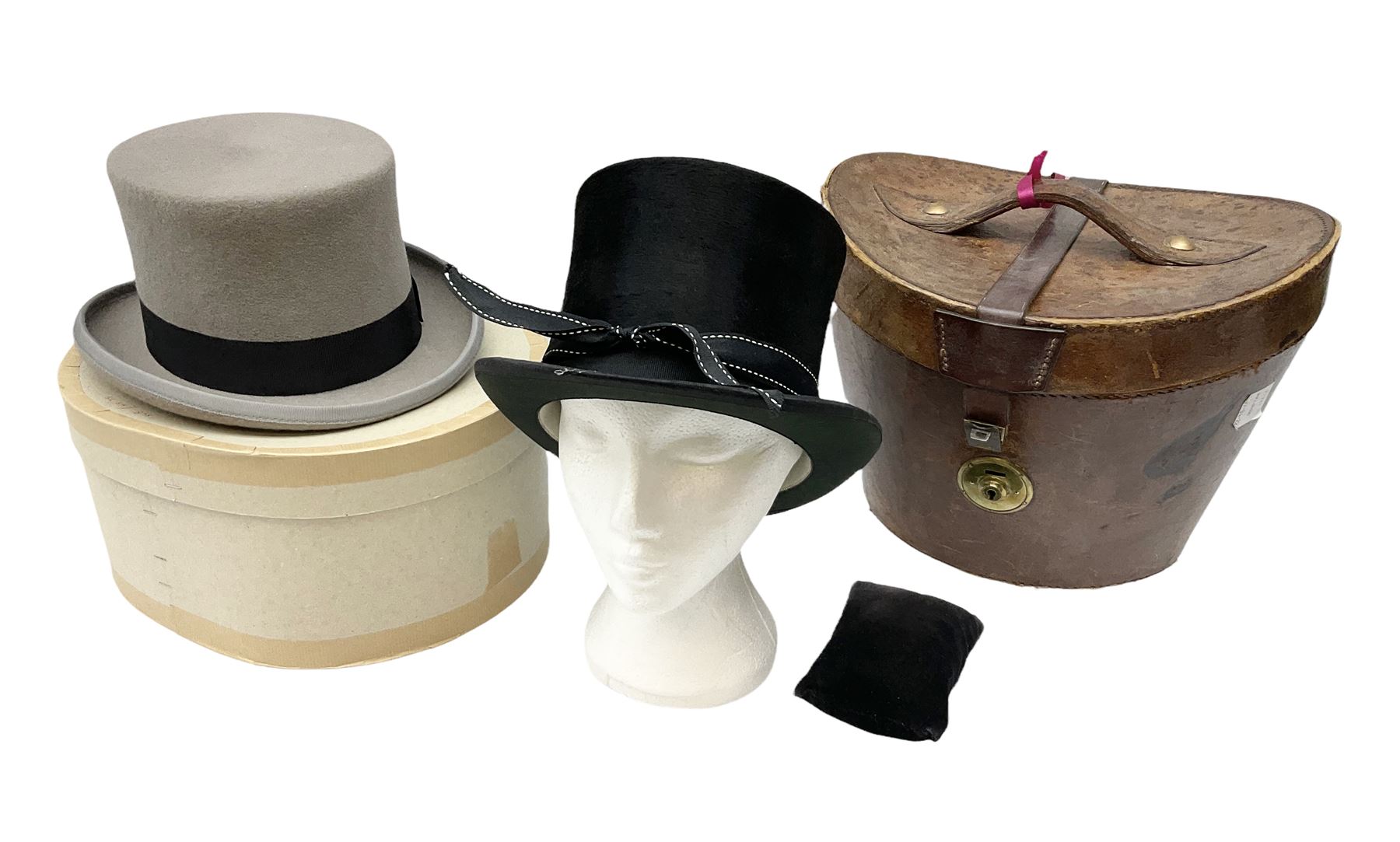 Leather hat box containing black felt top hat with 'British Manufacture' label, together with a grey top hat with 'Allens of Harrogate' label 