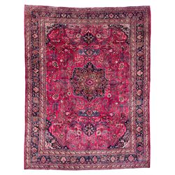 North East Persian Meshed fuschia ground carpet, the floral pole medallion flanked by banners with palmette motifs, surrounded by scrolling and interlaced branches of foliage, the border with bands of Boteh motifs, decorated with repeating stylised plant and flower head designs