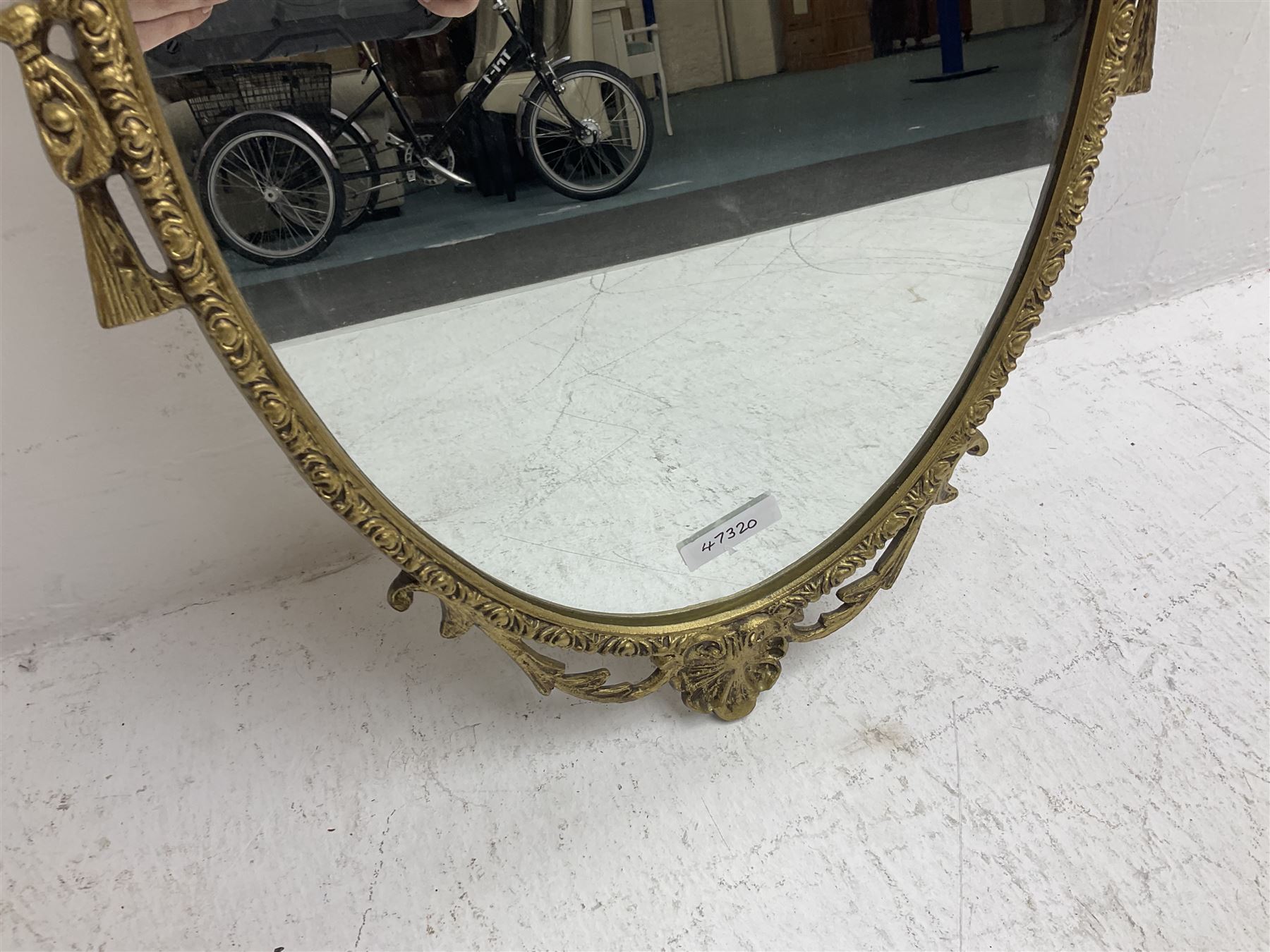 Ornate brass wall mirror with oval plate, L78cm