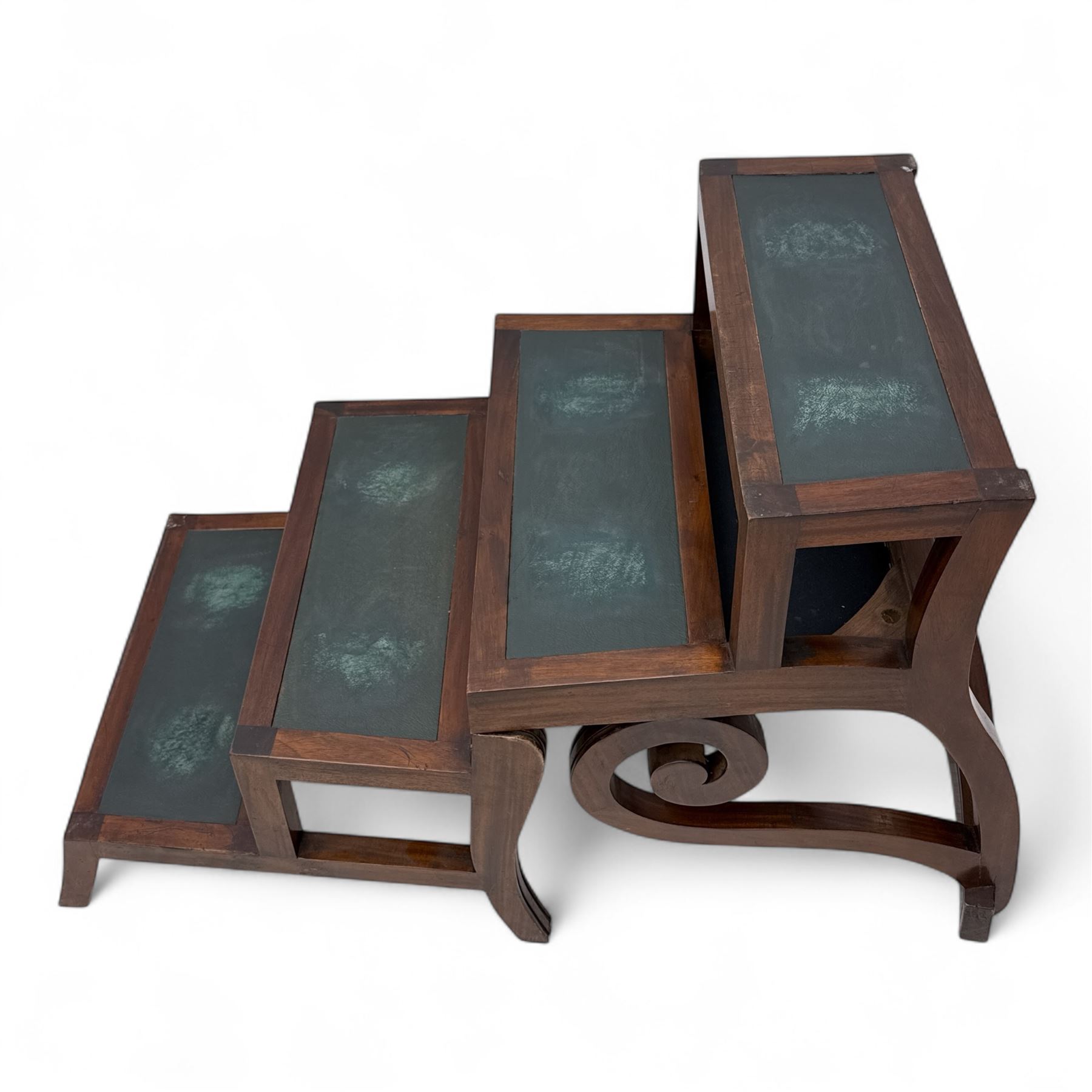 In the manner of Morgan & Sanders - early 20th century Regency design mahogany metaphoric library chair and steps, rectangular panelled top-rail with applied roundels with scrolling arms and upholstered seat and cushion, hinged and folding design transforming into four carpeted steps

Reference: The present lot is based on a design for a metamorphic library chair published by Morgan & Saunders circa 1810, P.Agius, Ackermann's Regency Furniture & Interiors, plate 29, page 60