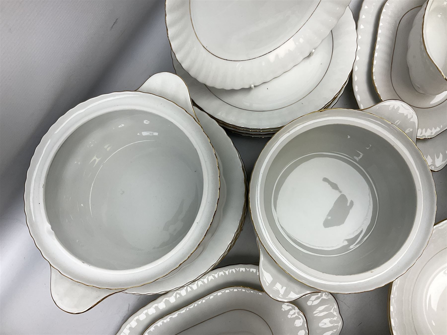 Chodziez Polish dinner wares decorated in white and gilt to include lidded twin handled tureens, bowls, plates etc