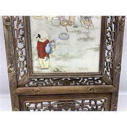 Japanese school framed ceramic panel depicting children in garden scene, signed and inscribed with black script, housed in pierced wood frame, overall L120cm