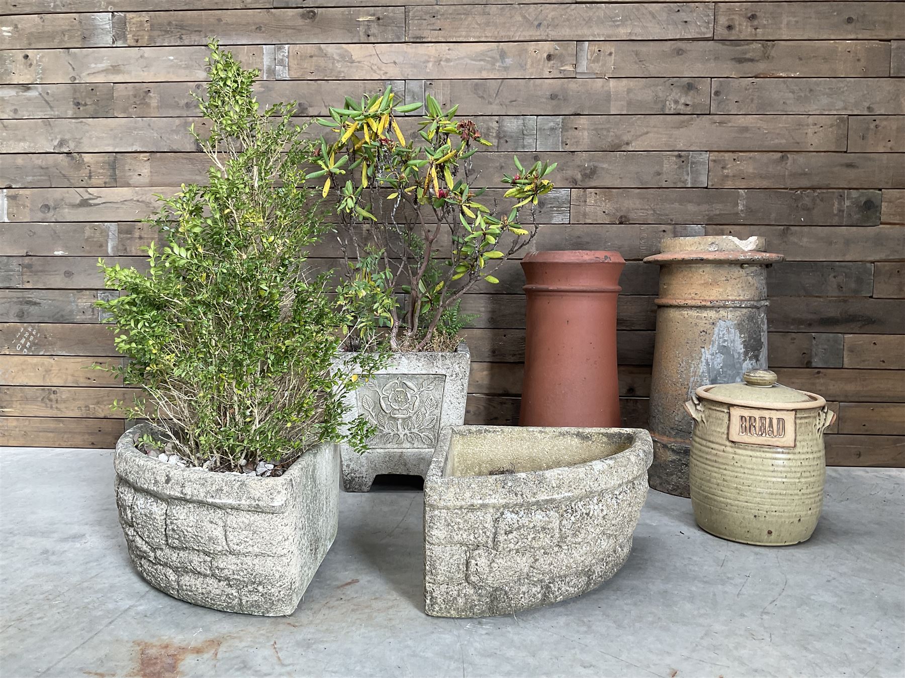 Two cast stone corner planters, square planter other Yorkshire Rose, two terracotta chimney pots and a terracotta bread bin (6)