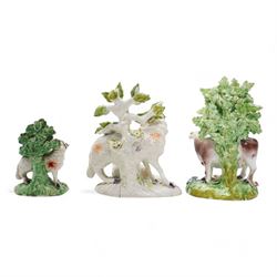 Two 18th century Derby porcelain groups modelled as a ram standing before bocage above a recumbent lamb, upon flower encrusted base, H15cm and two further Derby figures modelled as a ram and cow and calf (3)