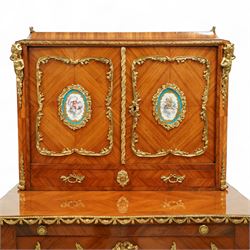 Late 19th century French Louis XV style kingwood and ormolu mounted bonheur du jour, the upper section with a pierced three-quarter gallery over a pair of cupboard doors inset with Sèvres-style porcelain portrait plaques, enclosing a shelved interior over two short drawers, the serpentine top and apron richly mounted with gilt-bronze foliate and scroll motifs, single frieze drawer below on cabriole supports with acanthus cast sabots
