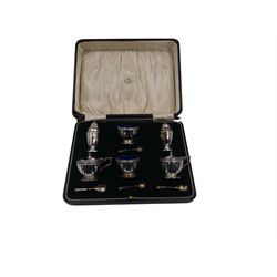 1920s silver six piece cruet set, comprising two mustard pots with covers, two open salts and two pepper pots, all of circular faceted form, mustards and salts with blue glass liners, hallmarked Mappin & Webb, Birmingham 1928, with four matched silver condiment spoons, hallmarked, contained within fitted case 