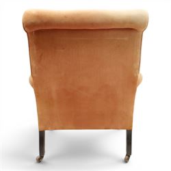 Victorian mahogany framed armchair of traditional shape, the high sprung rolled back over out-swept arms, deep sprung seat over turned feet with ceramic castors, upholstered in pale salmon pink fabric