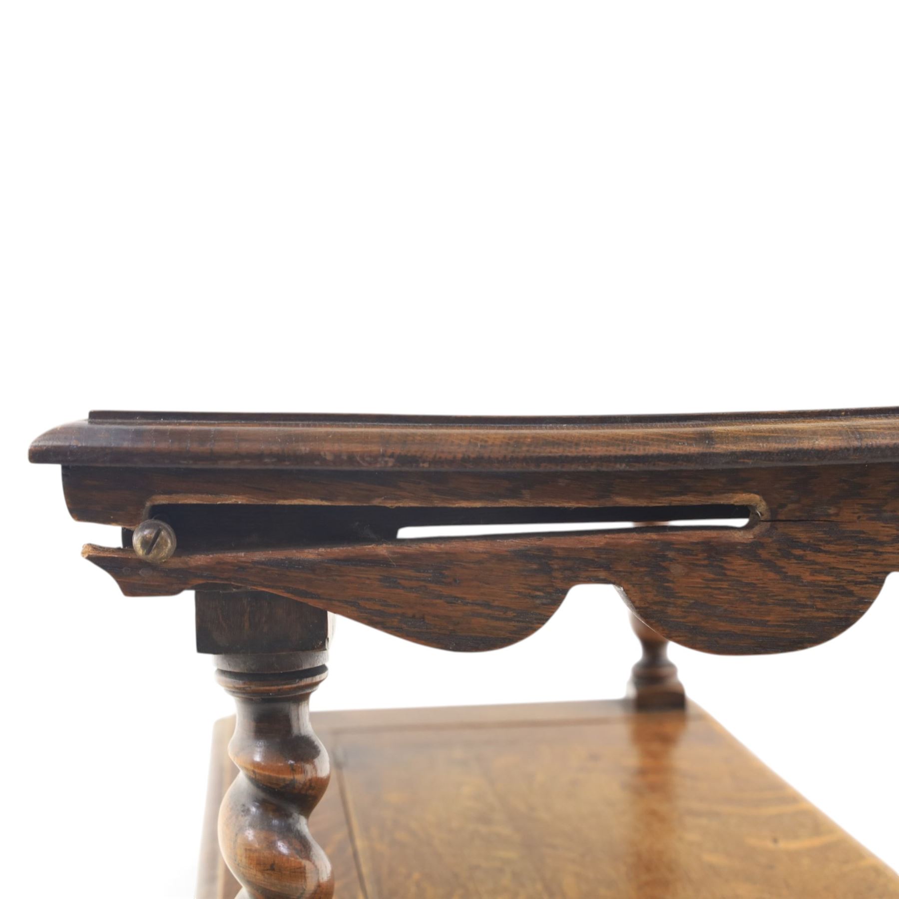 Early 20th century oak monks bench, panelled back converting to a table top, reeded armrests with barley twist uprights, hinged seat over panelled base supported on bun feet