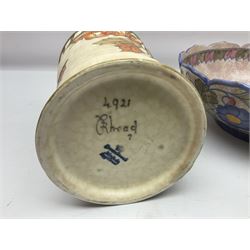 Charlotte Rhead for Crown Ducal ceramics, comprising coffin shaped vase depicting a woman in 1920s dress, a vase with handle, decorated with autumn leaves and a bowl, decorated with flowers and berries, with printed and signed marks beneath, coffin vase H24cm