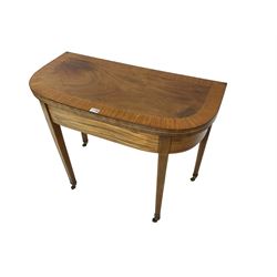 Early 19th century mahogany demi-lune card table, swivel fold-over top with satinwood band and baize lined interior, on square tapering supports with brass cups and castors