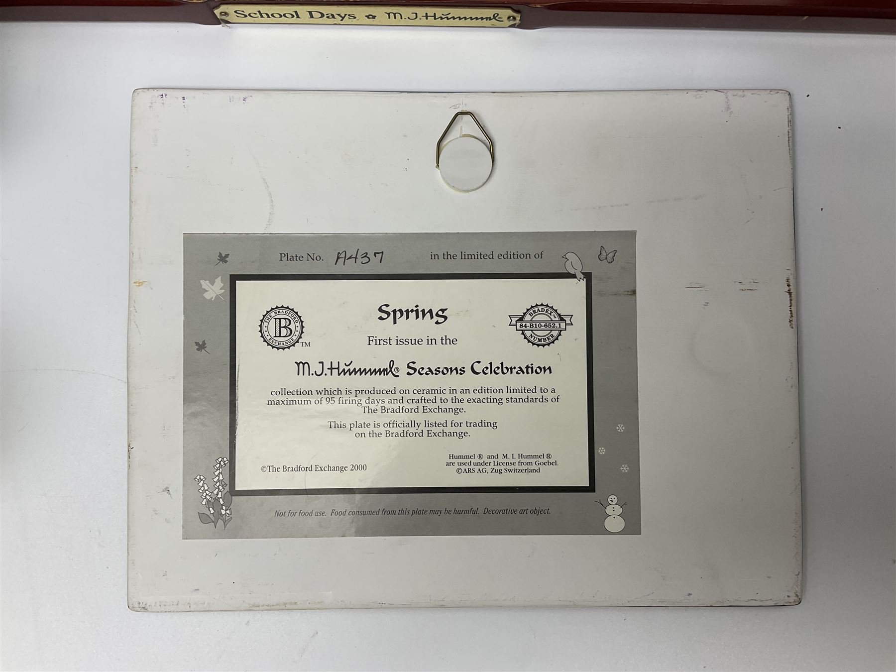 Two ceramic Hummel postcards by Goebel, both displayed on wooden easels, together nine Hummel eggs, set of four Hummel School Days plates, on wooden hanging rack, Goebel Collectors Club Member plaque etc