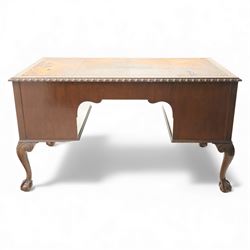 Waring & Gillow - Early 20th century mahogany desk, the leather-inset top above a shaped kneehole, central compartmented frieze drawer flanked by twin banks of of three drawers, each with brass handles, raised on cabriole legs with carved ball and claw feet (Height from floor to underside 62cm)