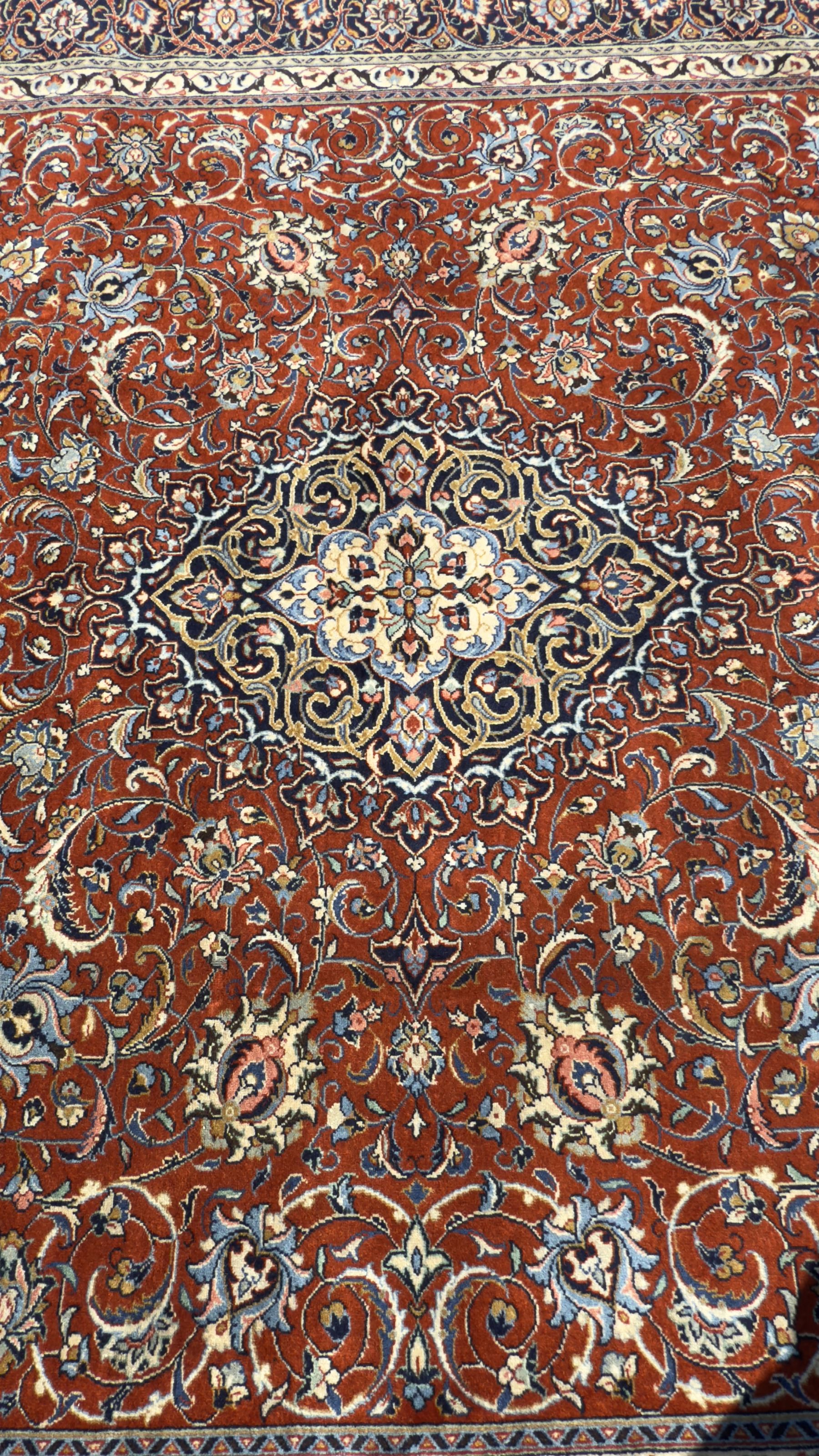 Central Persian Sarouk dark indigo and crimson ground rug, the medallion, field and spandrels decorated with repeating floral Herati motifs, the border decorated with scrolling branches and palmettes with small floral motifs, floral pattern guard stripes