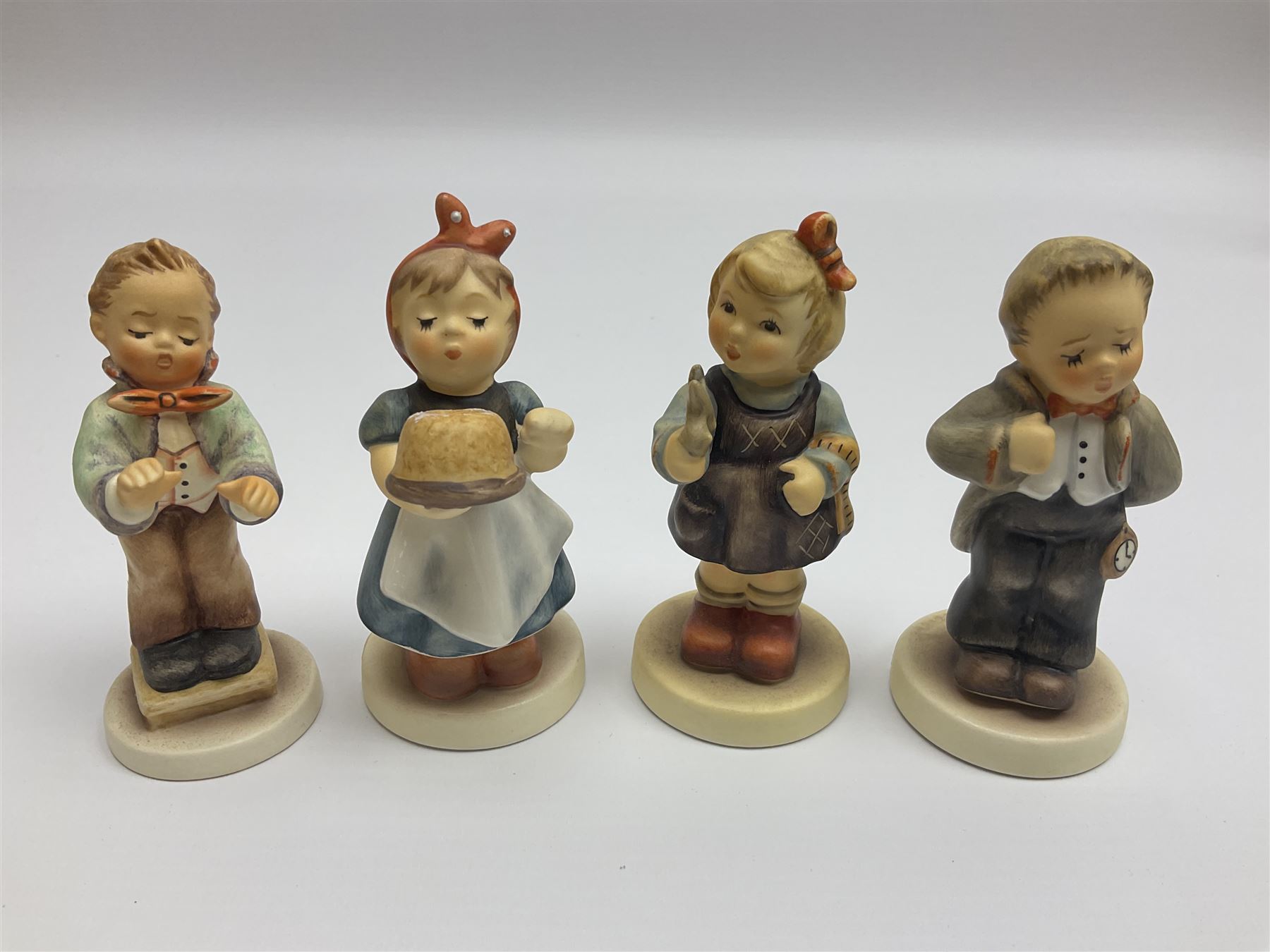 Thirty Hummel figures by Goebel, to include Saluting the Peacekeepers of Operation Joint Endeavor, on wooden plinth, Call to Glory, Celebrate with Song and Soldier Boy