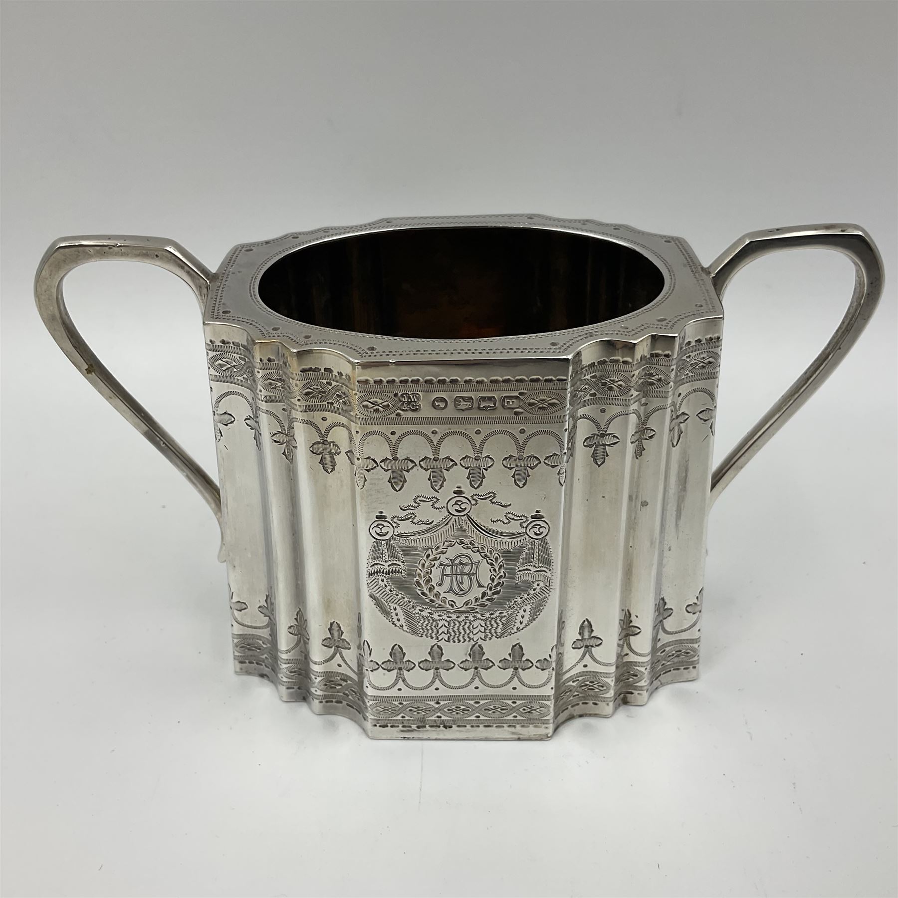 Victorian three-piece silver tea service, comprising teapot, twin handled open sucrier and milk jug, of oval form with shaped rim and C handles, each engraved with crests and bands of strapwork decoration, the milk jug and sucrier with gilt interiors, hallmarked Josiah Williams & Co, Exeter 1881, the teapot with ivory insulators and finial, all contained with a tooled leather, blue silk and velvet lined fitted case, retailed by West & Sun, Dublin 
This item has been registered for sale under Section 10 of the APHA Ivory Act