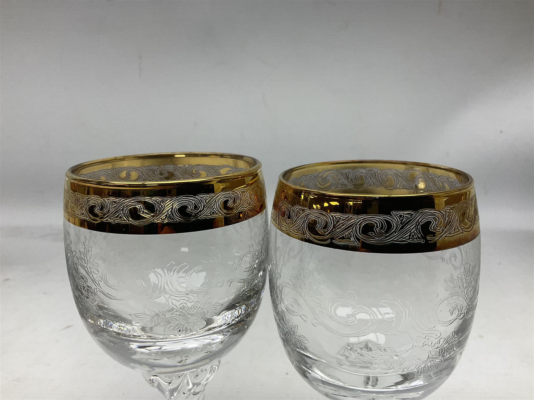 Set of twelve Moser style wine glasses, the bowls with etched floral bodies and gold banded rim with foliate decoration raised upon stem of twisted form, H14cm