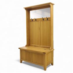 Modern light oak hall bench settle, with moulded cornice above a panelled back fitted with a row of metal coat hooks, over a hinged box seat opening to shoe storage, on tapered legs