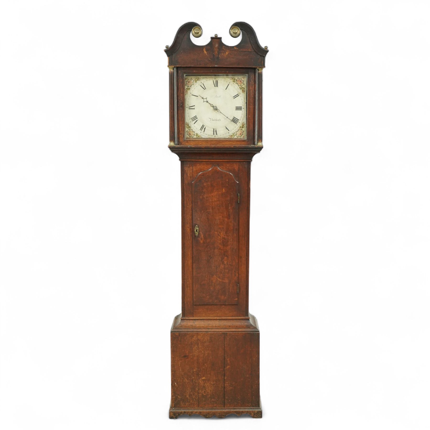 John Bull of Bedford-early 19th century provincial oak cased 30-hour longcase clock c 1830, with a swan necked pediment and brass patera, square hood door with detached reeded pilasters with brass capitals,
trunk with a long door with a shaped top on a square plinth with a shaped base, painted dial with floral spandrels, makers name, steel hands, Roman numerals and minute track, dial pined to a rope driven countwheel striking movement, striking the hours on a bell. With pendulum.
John Bull (1802-1870) was the founding father of a prodigious family of Bedfordshire clockmakers working in Bedford from the early 19th century until the mid 20th century. 