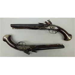  Pair of mid 18th century French flintlock 26 bore side-by-side double barrel holster pistols by Mercier a Paris, 24cm tapering sighted barrels, engraved hammer and lock-plate, full walnut stock with carved detail, the silver trigger guard with urn finial and butt cap cast with the head of a Sun God, the silver crowned cartouche engraved with a crest and flanked by birds and with silver wire tendrils, with wood ramrod in silver pipes 42cm overall  