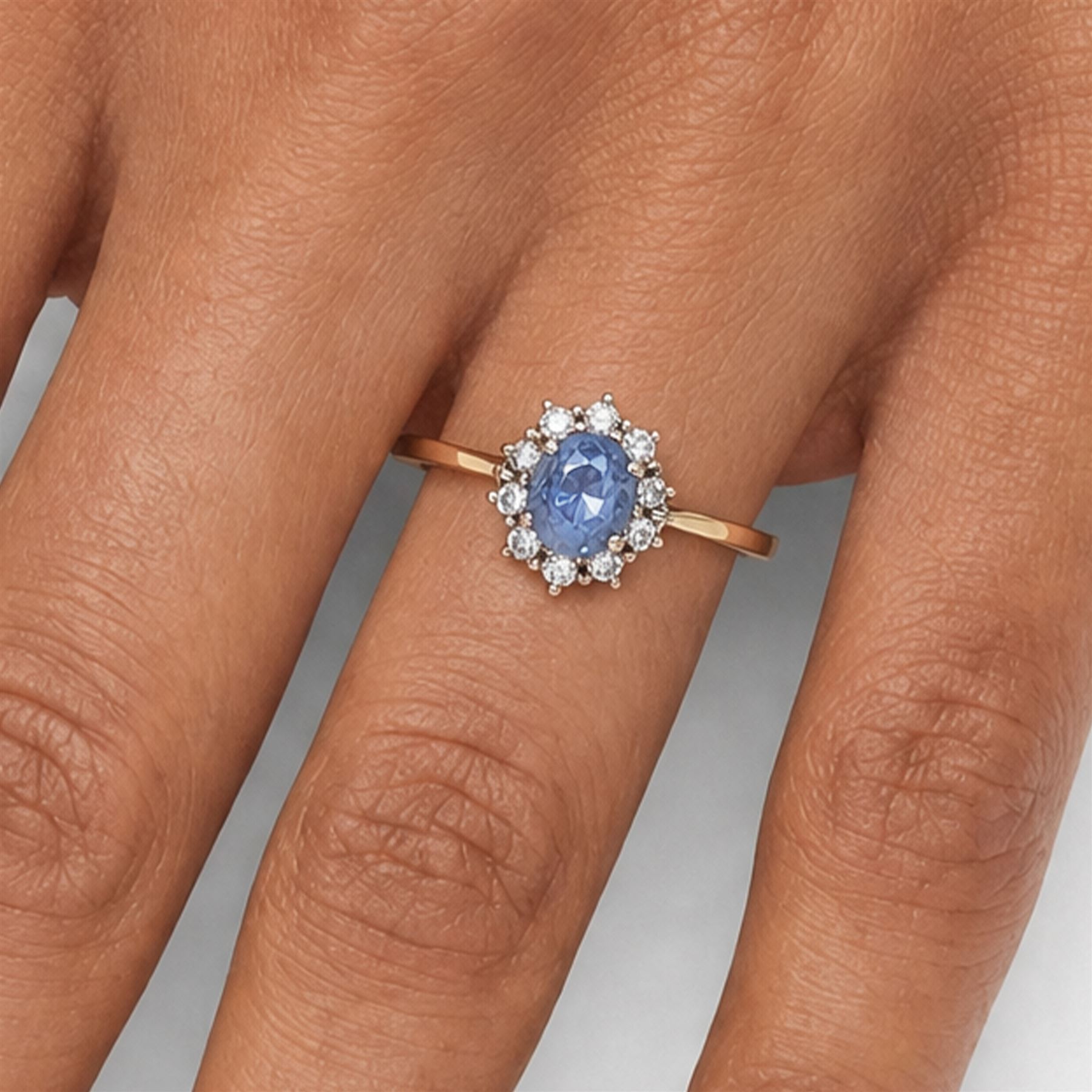 18ct gold sapphire and diamond cluster ring, oval cut sapphire of approx 1.50 carat, surrounded by ten round brilliant cut diamonds, Birmingham import mark 1981, total diamond weight approx 0.30 carat