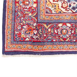 North West Persian carpet, the indigo field centred by a lobed medallion in pale blue and ochre with floral pendants, profusely decorated with scrolling foliage, palmettes and flowerheads, ivory floral spandrels, enclosed by a red ground palmette border and multiple floral guard bands