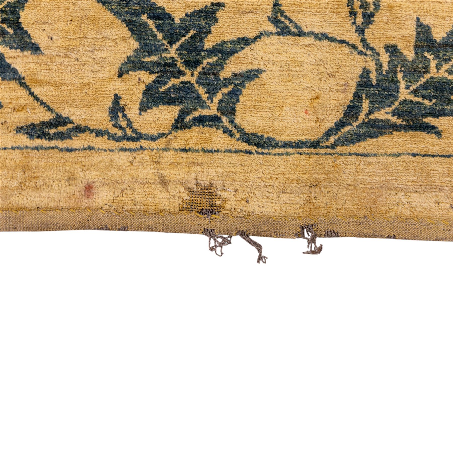 Late 20th century Turkish hand-woven carpet, golden beige field decorated with a repeating lattice of stylized medallions enclosing boteh and angular foliate motifs linked by issuing scrolling vinery within a border of complementary stylized leaf scrolls