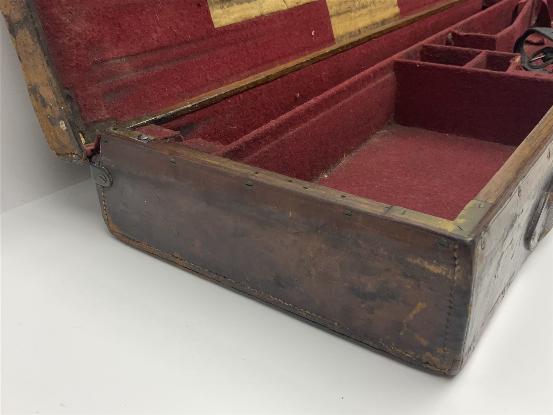Leather shotgun case, the red baize lined interior with the trade labels of Westley Richards & Co., London, a brass plaque inscribed 'T Nevin, Mirfield, Yorkshire' to cover, with key, case to fit barrel 76cm (30 inches)  
