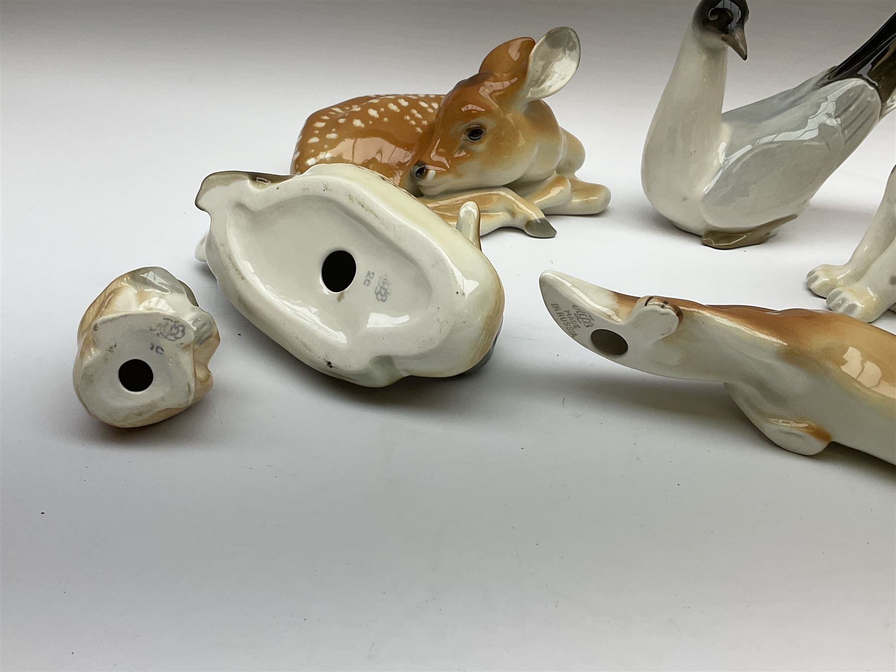 Group of Russian USSR animal figures by Lomonosov, to include examples modelled as an outstretched hunting fox, kitten, lion cubs, seagull/tern etc, all with stamped marks beneath, together with a model of a recumbent deer with no marks, tallest H14cm