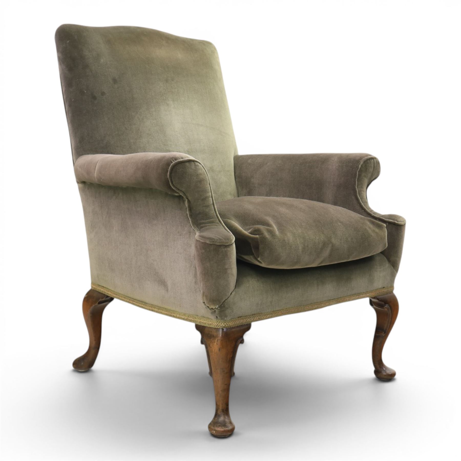 Pair of Georgian style wing armchairs, upholstered in green velvet, each with shaped wing backs, padded scroll arms and loose seat cushions, raised on cabriole supports terminating in pad feet, one with tasselled fringe