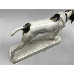 Early 20th century Katzhütte figure of a pointer dog, and figure of a young girl holding basket and fan, both with green cat H house printed mark beneath, dog L25cm