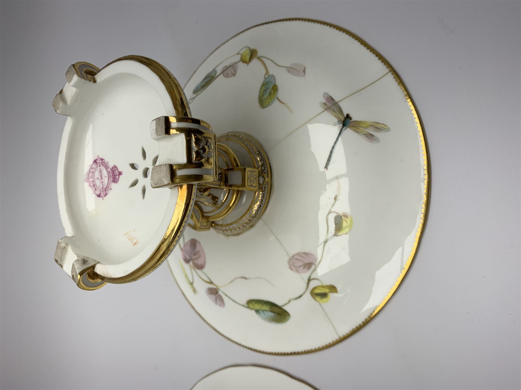 19th century Minton dessert service, comprising four comports, one tazza, and twelve plates, each hand painted with birds perched upon branches, and further detailed with insects and heightened in gilt, with printed retailers mark beneath for John Mortlock Oxford Street London, and impressed Minton mark to most, comport H13.5cm, plates D23.5cm. 
