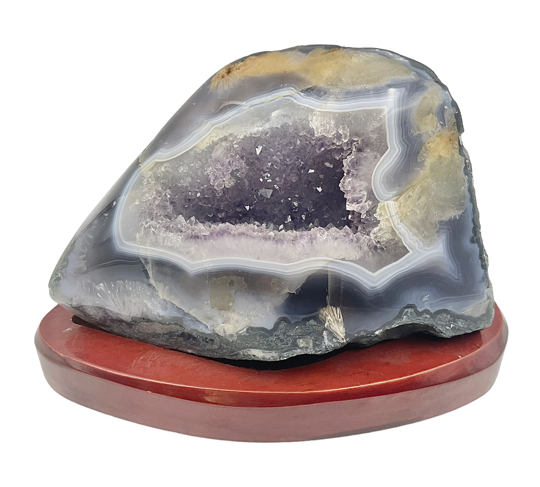 Amethyst crystal geode cluster, with well-defined crystals of various sizes, upon a carved wooden stand, H12cm, L20cm