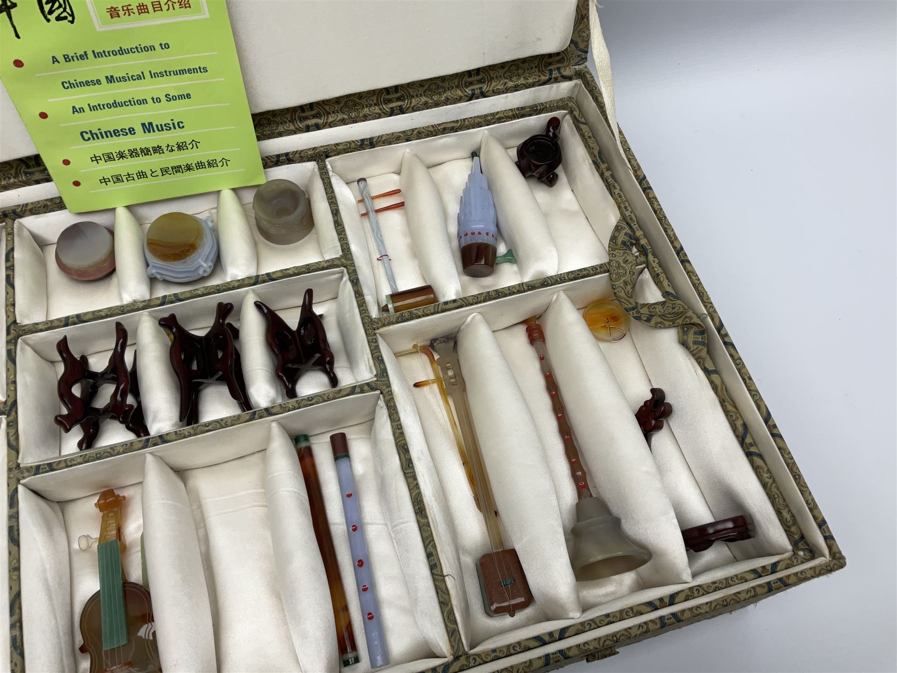 Chinese boxed collection of miniature polished hardstone musical instruments with hardwood stands