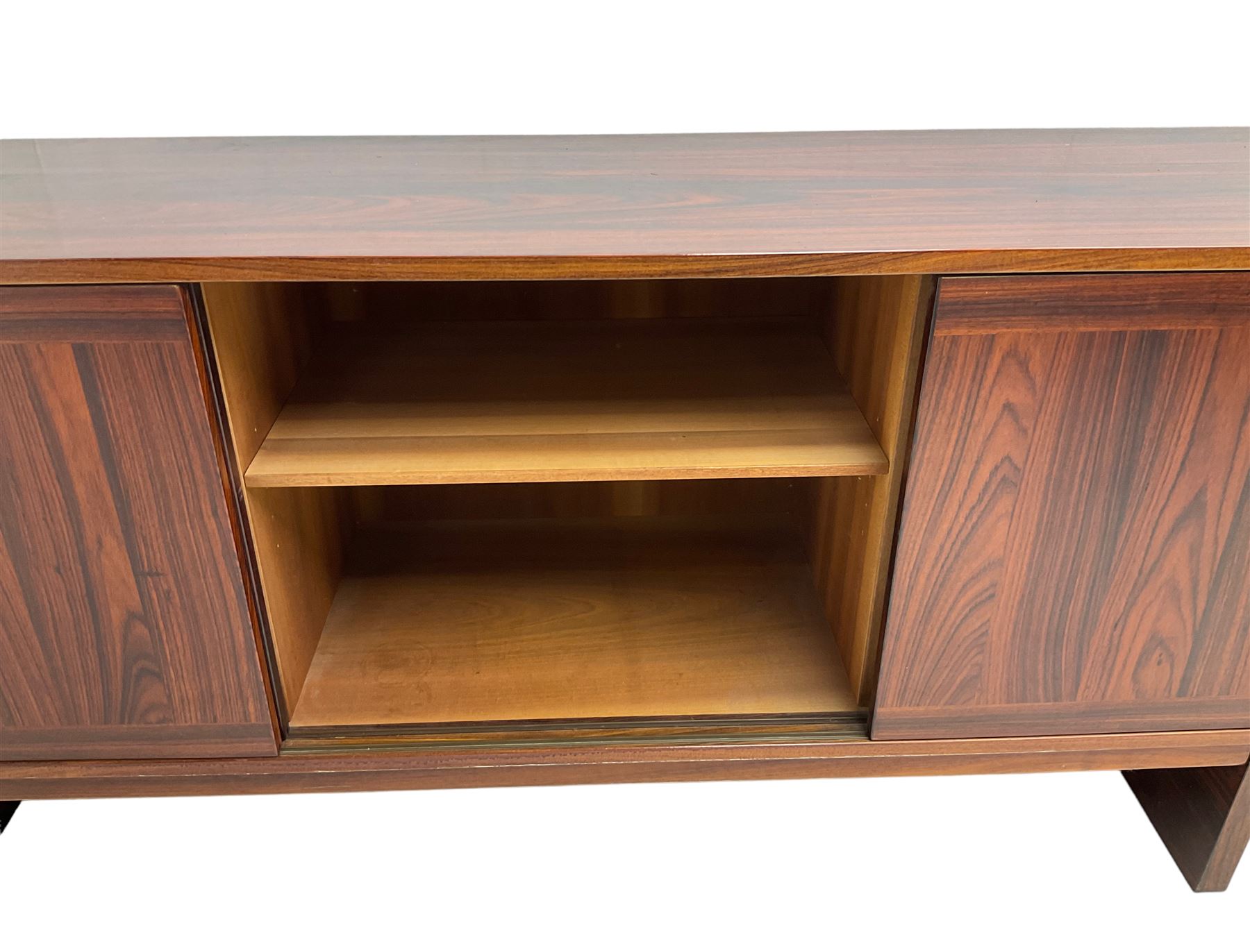 NH Chapman & Co Siesta - mid-20th century sideboard, fitted with three sliding doors, enclosing two drawers and shelves, raised on twin end supports